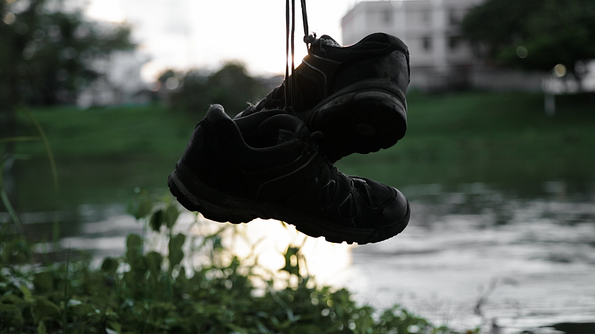 Hiking shoes hanging against a river backdrop